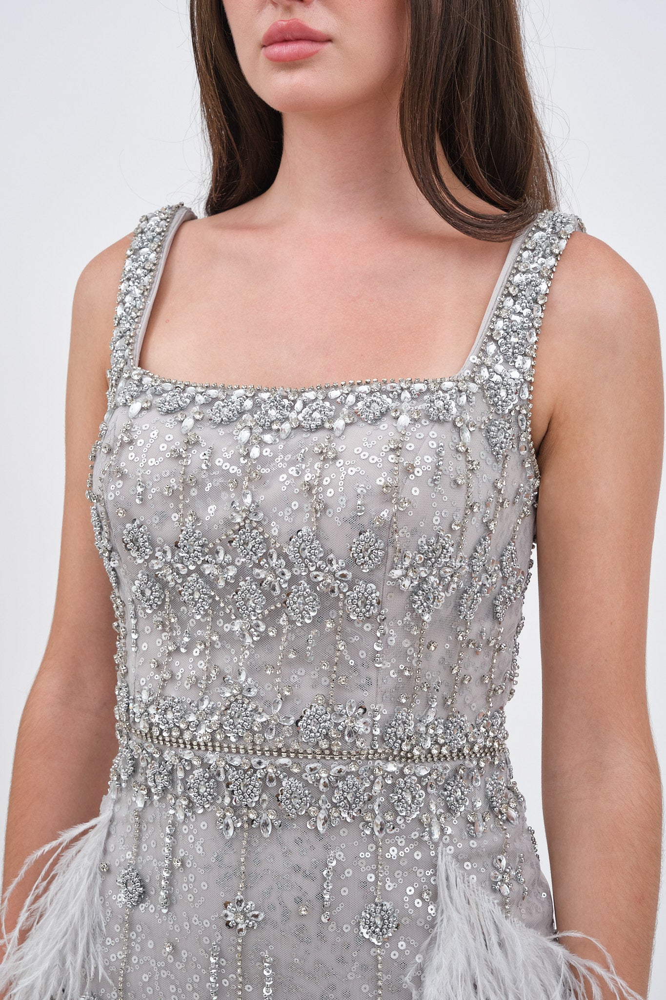 Robe de Soirée Argentée avec Détail en Plumes et Traîne Élégante