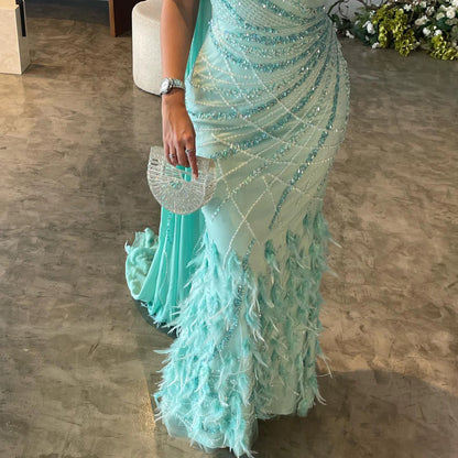 Robe asymétrique brodée avec plumes et traîne